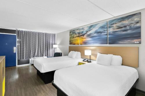 a hotel room with two beds and a window at Days Inn by Wyndham Seneca-Clemson in Seneca