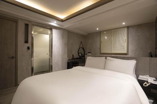 a bedroom with a large white bed in it at hotel louize in Seoul