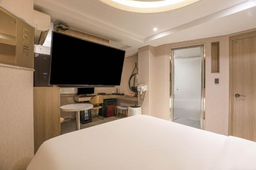 a bedroom with a large television on the wall at hotel louize in Seoul