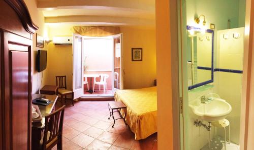 a bathroom with a bed and a sink in a room at Hotel Mediterraneo in Siracusa