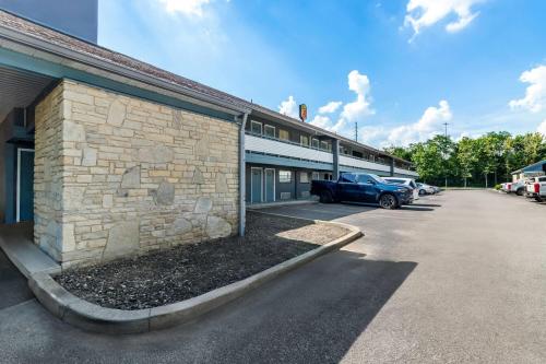 a building with a car parked in a parking lot at Super 8 by Wyndham Cincinnati-Springdale OH in Springdale