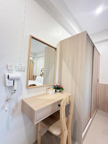 a bathroom with a vanity with a mirror and a chair at Chertam Le Marjestic Hotel โรงแรม เฌอแตม ลำปาง in Ban Kat Mek