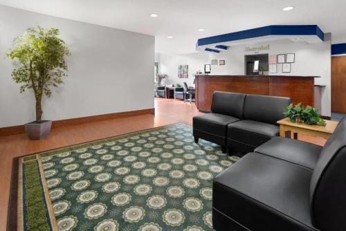 a lobby with a waiting room with a couch and a table at Microtel Inn by Wyndham - Albany Airport in Latham