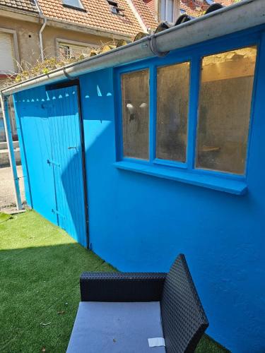 a blue house with a blue door and a bench at Chambre privée à 50 m de la plage- Parking privé, salle de bain et cuisine commune in Le Portel