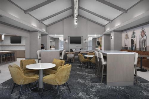 a room with tables and chairs and a tv at Homewood Suites by Hilton Princeton in Princeton