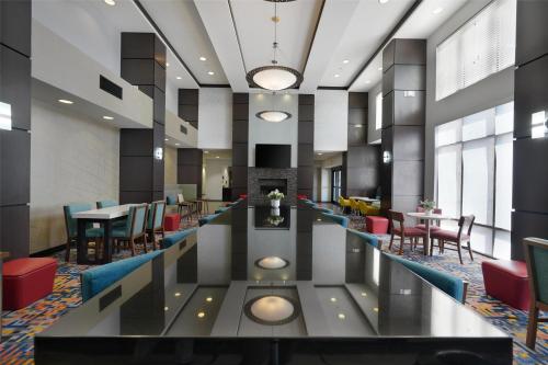 a lobby of a hotel with tables and chairs at Hampton Inn & Suites Tulsa/Tulsa Hills in Tulsa