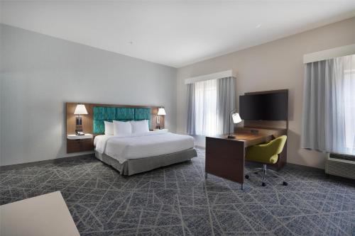 a hotel room with a bed and a desk and a television at Hampton Inn & Suites Tulsa/Tulsa Hills in Tulsa