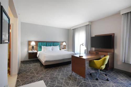 a hotel room with a bed and a desk with a computer at Hampton Inn & Suites Tulsa/Tulsa Hills in Tulsa