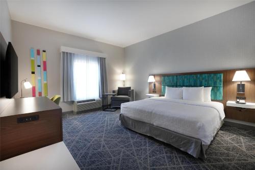 a hotel room with a large bed and a desk at Hampton Inn & Suites Tulsa/Tulsa Hills in Tulsa