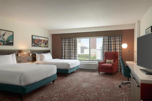 a hotel room with two beds and a chair at Hilton Garden Inn Atlanta Downtown in Atlanta
