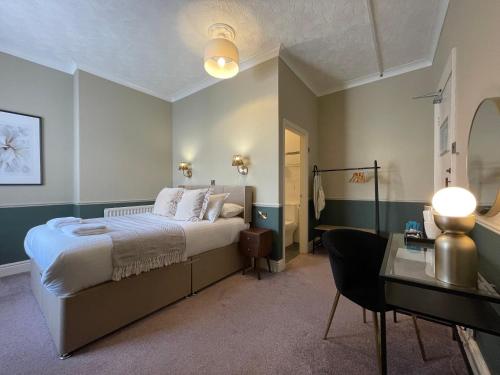 a bedroom with a bed and a desk and a table at Wedgwood Hotel, North Shore Room in Llandudno