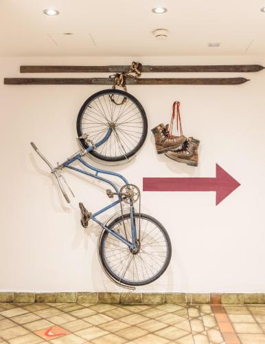 a bike hanging on a wall with an arrow at Hotel Glemmtalerhof in Saalbach Hinterglemm