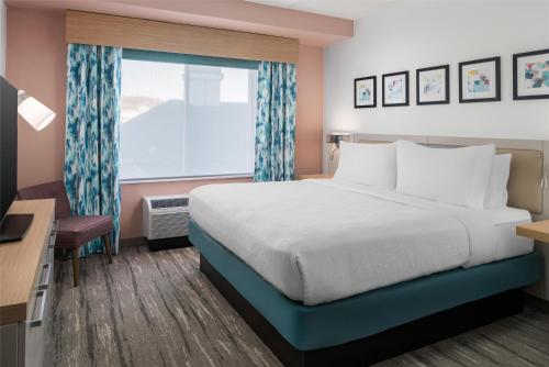 a hotel room with a bed and a window at Hilton Garden Inn Rockaway in Rockaway