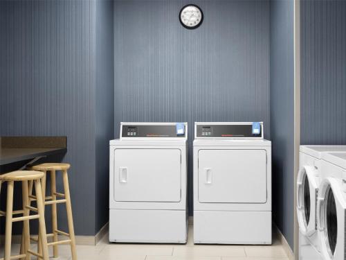 two washing machines and a clock on a wall at Homewood Suites by Hilton Akron/Fairlawn in Akron