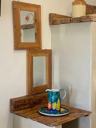 a vase sitting on a wooden shelf with a plate at ALEMINAS House 1 in Symi