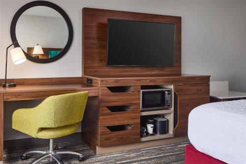 a room with a bed and a television and a chair at Hampton Inn Colby in Colby