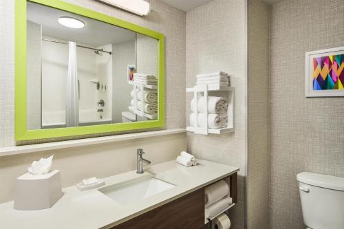 a bathroom with a sink and a mirror and a toilet at Hampton Inn Colby in Colby