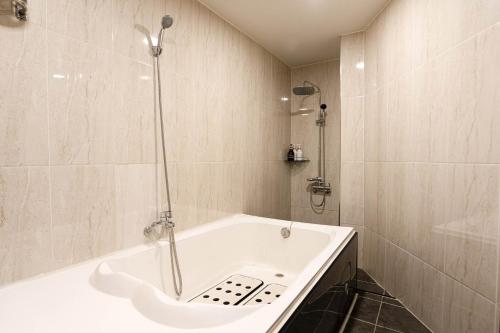 a bathroom with a bath tub and a shower at hotel louize in Seoul
