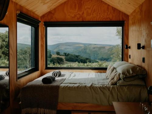 a bedroom with a bed and a large window at Hoku in Llangollen