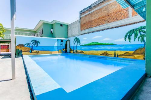 a swimming pool with a mural of the beach at OYO Hotel Margarita in Tlaquiltenango