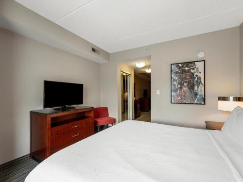 a hotel room with a bed and a flat screen tv at Hilton Garden Inn Winchester in Winchester