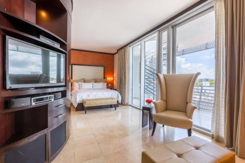 um quarto de hotel com uma televisão e uma cama em SBV Luxury Ocean Hotel Suites em Miami Beach