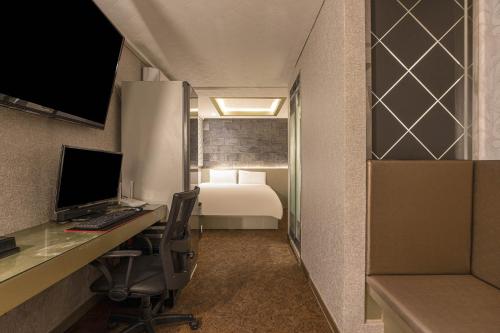 a room with a desk with a computer and a bed at hotel louize in Seoul