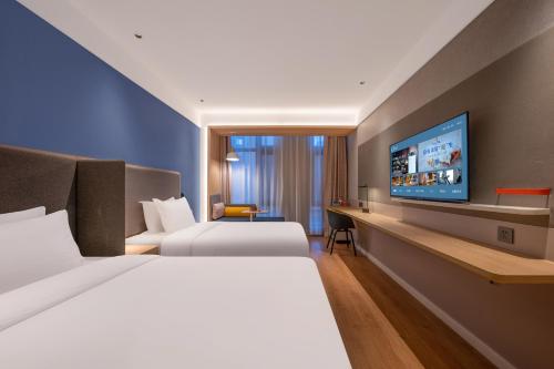 a hotel room with two beds and a flat screen tv at Orange Hotel, Longhu Paradise Walk, Daxing Biomedical Base, Beijing in Beijing