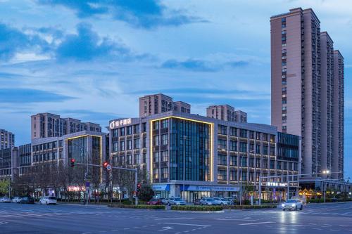 a city with tall buildings and a street with a traffic light at Orange Hotel, Longhu Paradise Walk, Daxing Biomedical Base, Beijing in Beijing