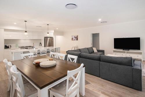 a living room with a table and a couch at Tidal Treasure Family Home B in Busselton