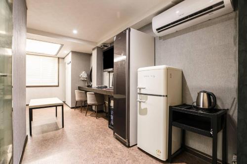 a small kitchen with a refrigerator and a table at hotel louize in Seoul