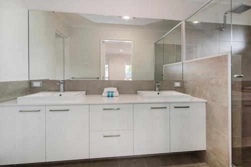 a bathroom with two sinks and a large mirror at Tidal Treasure Family Home B in Busselton