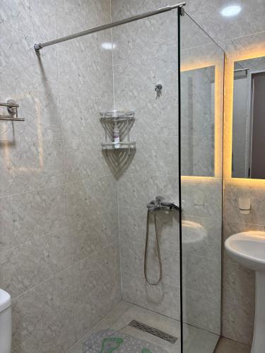 a shower with a glass door and a sink at Sataplia Inn in Tskaltubo