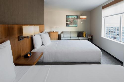 a hotel room with a large bed and a chair at Hyatt Place Long Island City in Queens