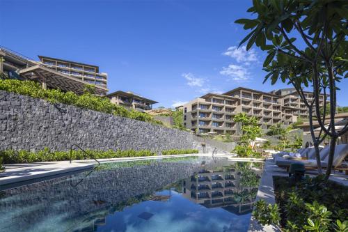 a pool at a resort with buildings in the background at Waldorf Astoria Costa Rica Punta Cacique in Playa Hermosa