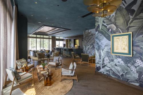 a lobby with chairs and a wall with a mural at Waldorf Astoria Costa Rica Punta Cacique in Playa Hermosa