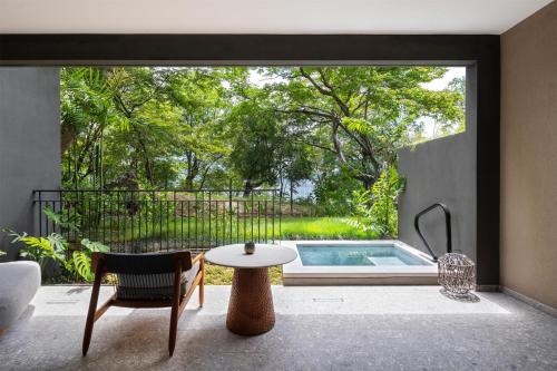 a living room with a table and a pool at Waldorf Astoria Costa Rica Punta Cacique in Playa Hermosa