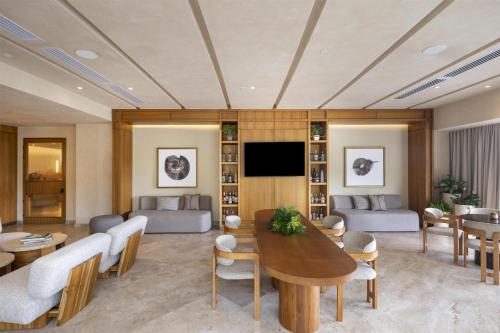 a living room with a table and a tv at Waldorf Astoria Costa Rica Punta Cacique in Playa Hermosa