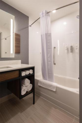 a bathroom with a sink and a tub and a shower at Hilton Garden Inn Dayton Downtown in Dayton