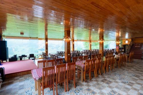 a dining room with tables and chairs and windows at Eco Farmer House - Sapa Retreat in Sa Pa