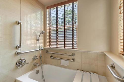 a bathroom with a tub and a shower and a window at Hilton Vacation Club Greensprings Williamsburg in Williamsburg