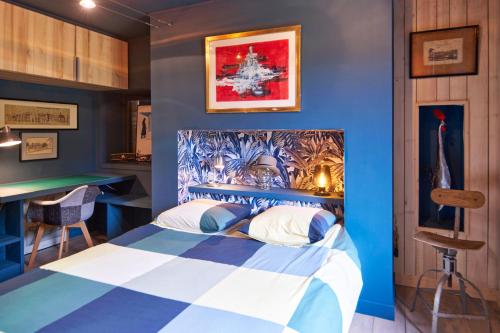 a bedroom with a bed with a blue wall at Au Bout du Chemin - Vue Chateau in Vitrac