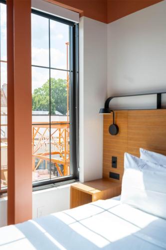 a bedroom with a bed and a large window at The Myriad Hotel Louisville, Tapestry Collection by Hilton in Louisville