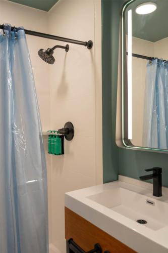 a bathroom with a sink and a mirror at The Myriad Hotel Louisville, Tapestry Collection by Hilton in Louisville