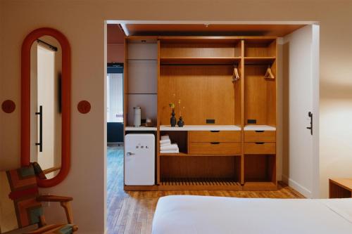 a room with a bed and a kitchen with a refrigerator at The Myriad Hotel Louisville, Tapestry Collection by Hilton in Louisville