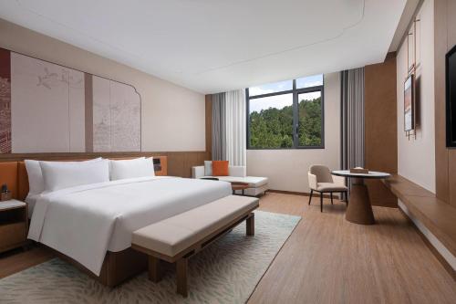 Una habitación de hotel con una cama grande y una mesa. en La Quinta by Wyndham Suzhou Yangshan, en Suzhou