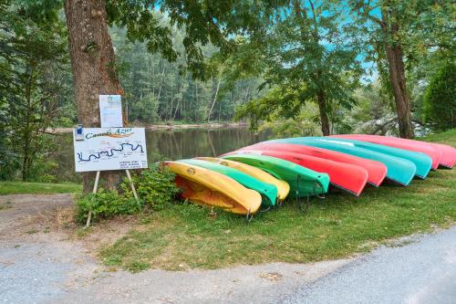 a row of kayaks lined up next to a lake at Au Bout du Chemin - Vue Chateau in Vitrac