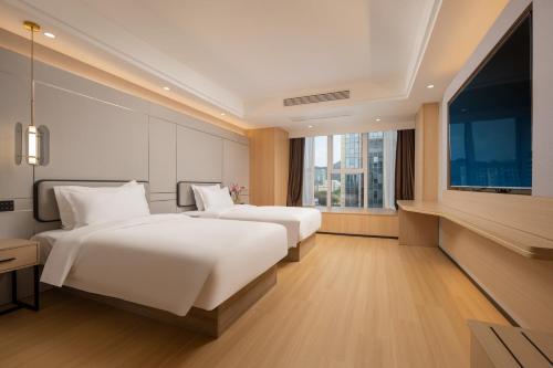 a hotel room with two beds and a flat screen tv at Vyluk Hotel-Xixi Wetland Lingyin Temple West Lake in Hangzhou