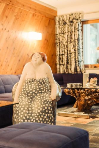 a woman sitting in a chair in a living room at Hotel Glemmtalerhof in Saalbach Hinterglemm