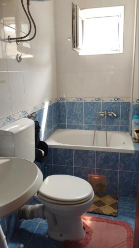 a bathroom with a toilet and a sink and a tub at Nada Rooms in Budva